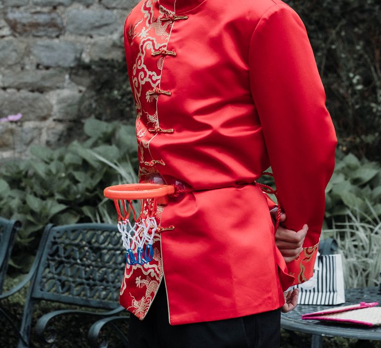 Groom waits for his bride in red traditional Chinese attire on wedding day for Chinese Tea Ceremony