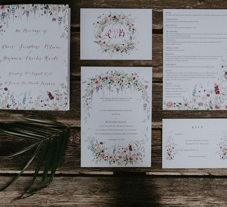 Floral wedding stationery with red ink calligraphy on a wooden table for Surrey summer wedding