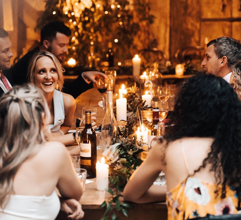 Wedding guests laugh and smile during reception