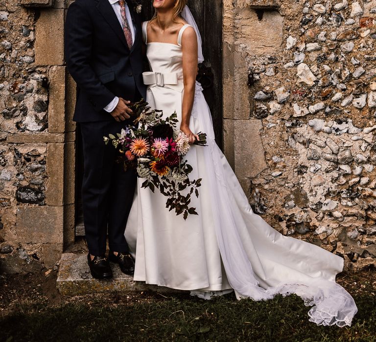 Bride and groom share a moment outside church