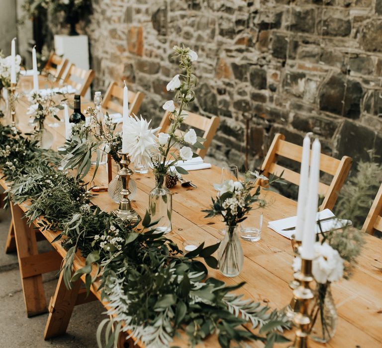 Foliage table runner with white flowers on wooden table