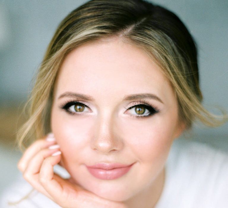 Beautiful bride with smokey eye makeup, light brown lipstick and shimmering highlighter 