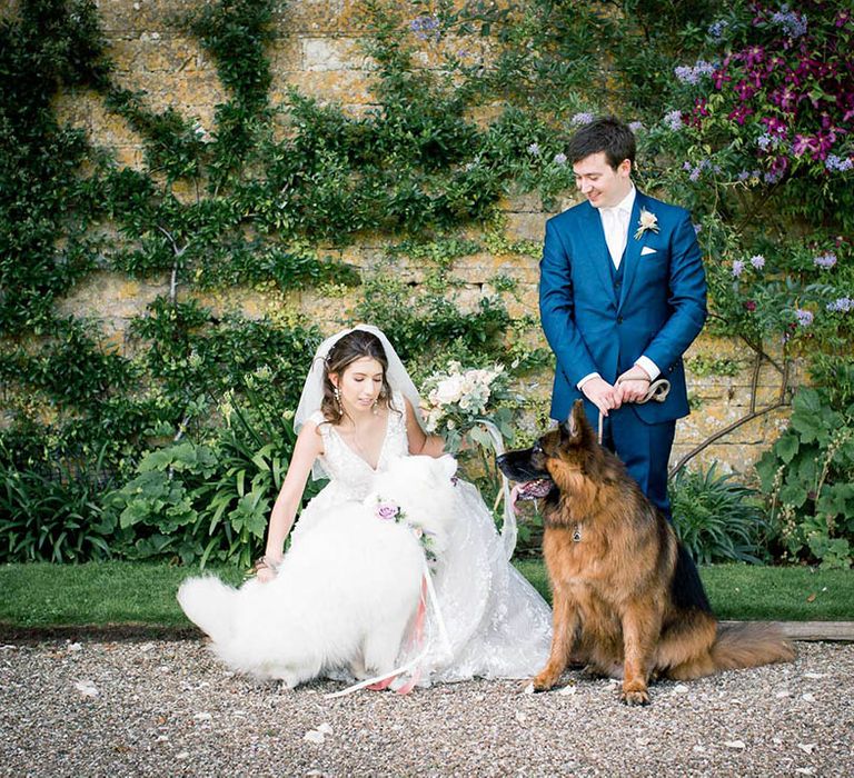 Bride & groom stand with their dogs on their wedding day outdoors