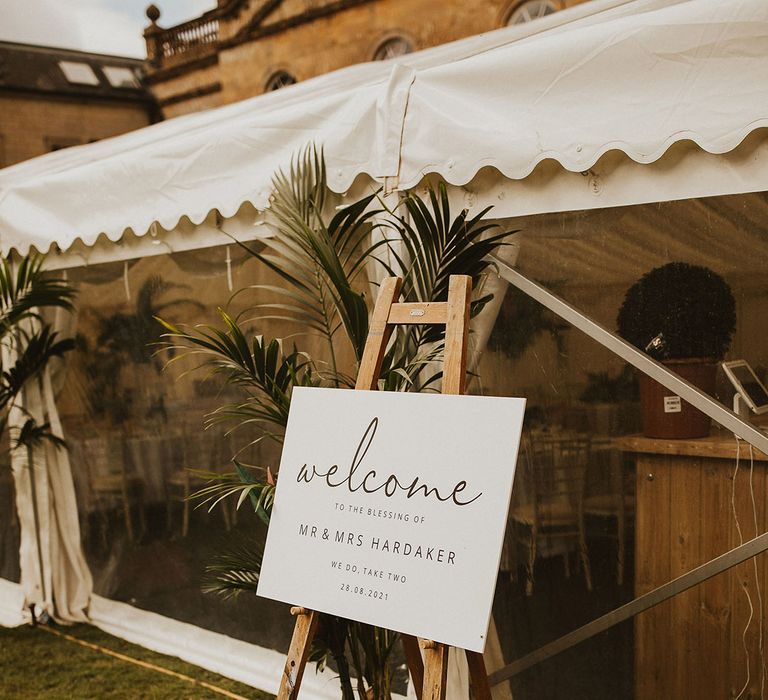 Welcome signage on wooden easel outside marquee