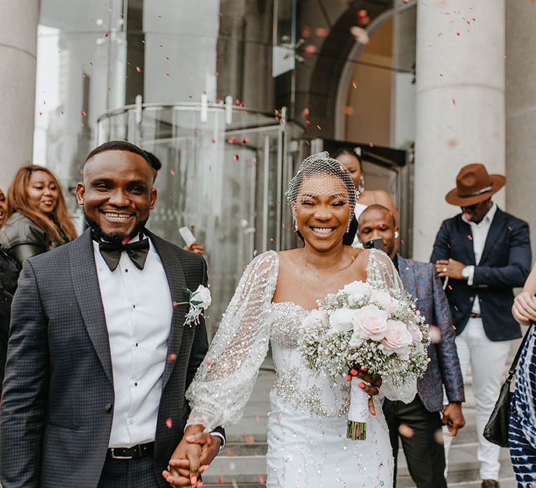 Bride & groom walk through confetti on their wedding day 