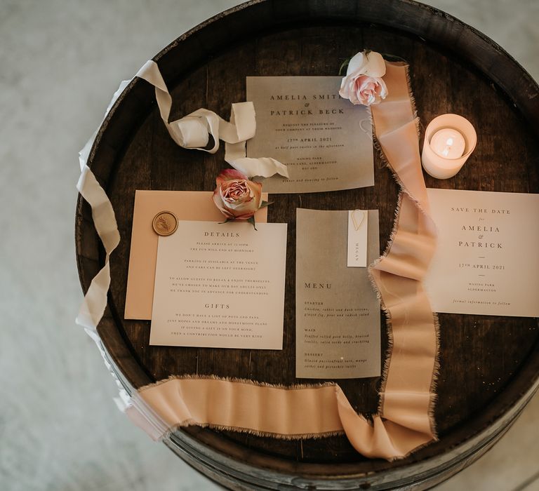 Neutral wedding stationery complete with typewriter finish and ribbon across wooden table