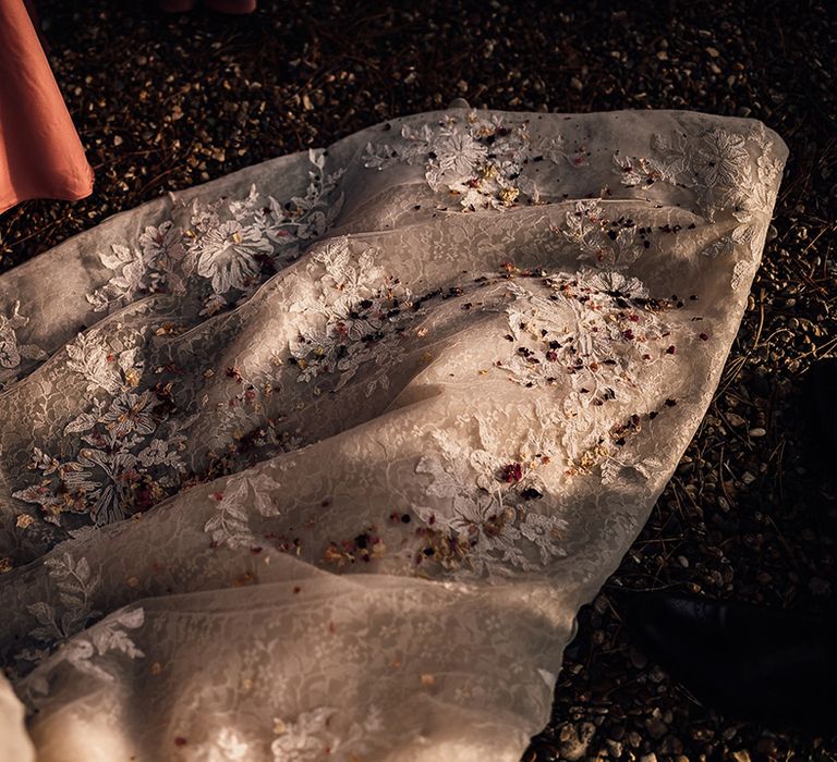 Confetti on the lace train of bride's dress