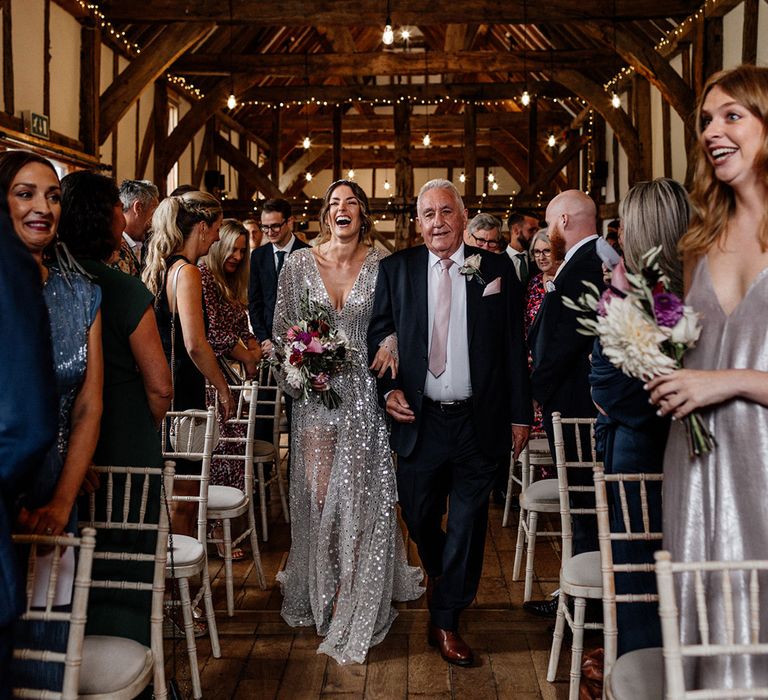 Tithe Barn, Loseley House wedding ceremony with Father of the bride in a navy suit walking his daughter down the aisle in a grey coloured wedding dress