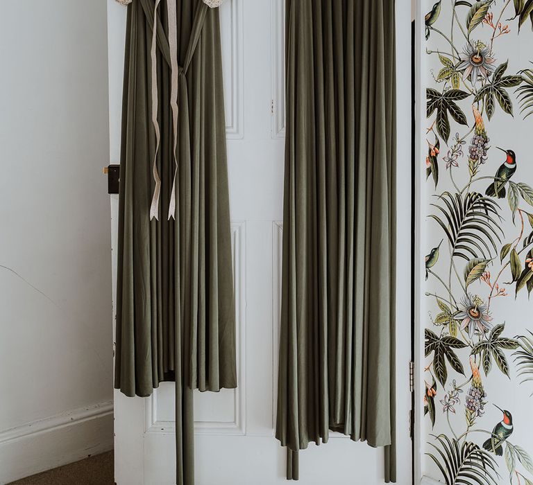 Green bridesmaids dresses hang before wedding day