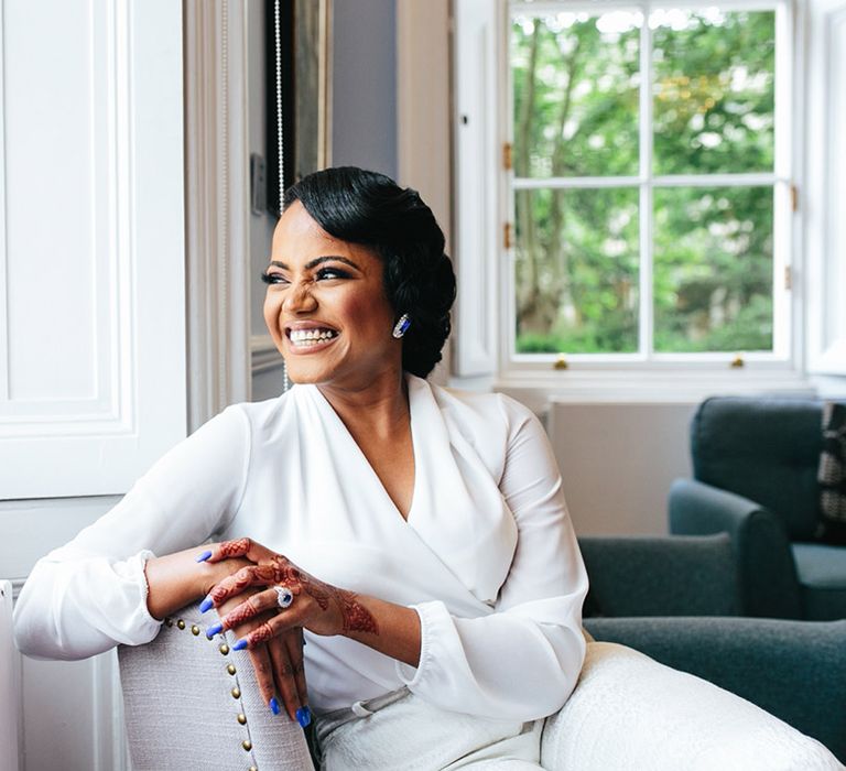 Bride smiles on her wedding day whilst wearing white dressing gown