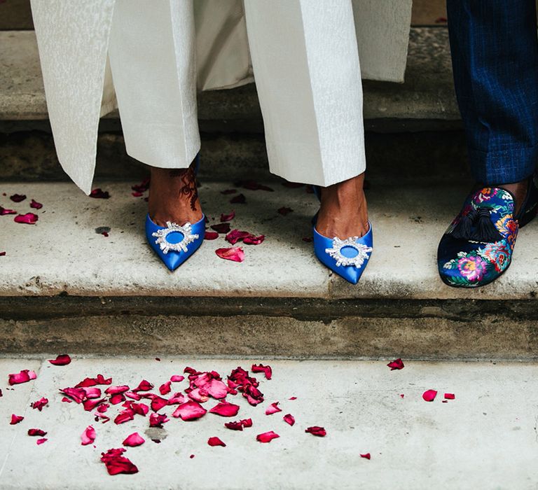 Bride wears blue wedding shoes complete with embellished pointed toes 