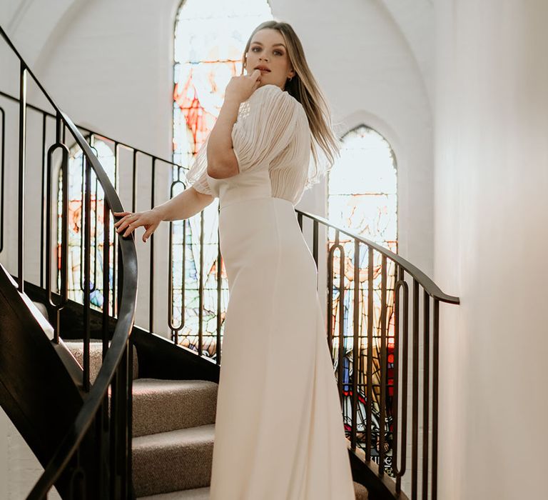 Bride in an A-line wedding dress with a pleated sheer back wedding dress and cap sleeves 