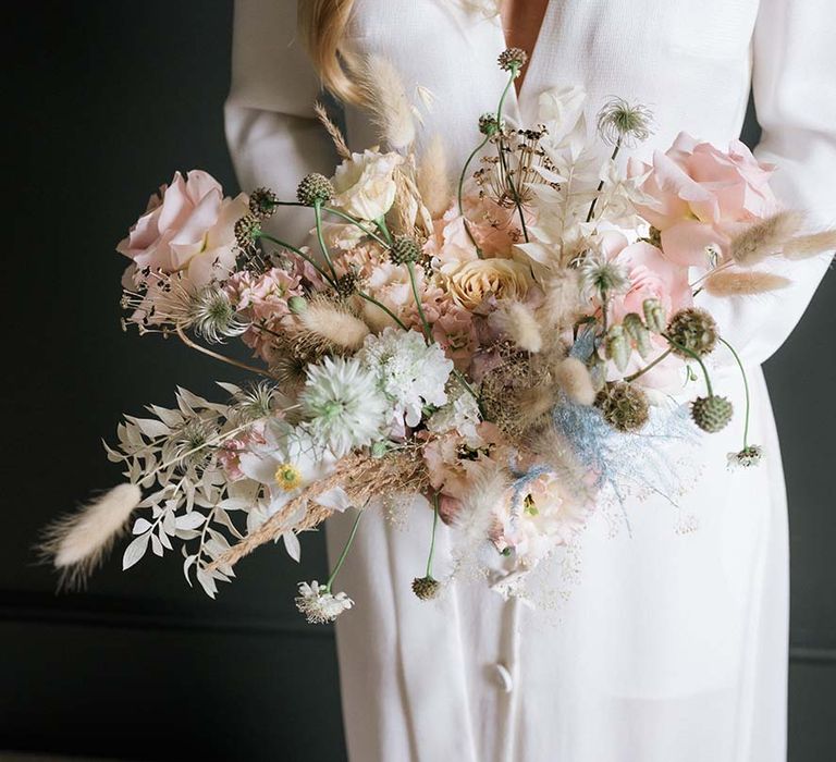 Bride's wedding bouquet of pastel summer flowers and pampas grass