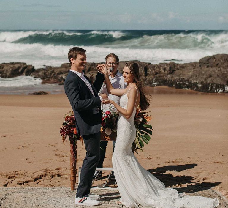 Bride and groom smile at their guests as a married couple for beach ceremony in South Africa