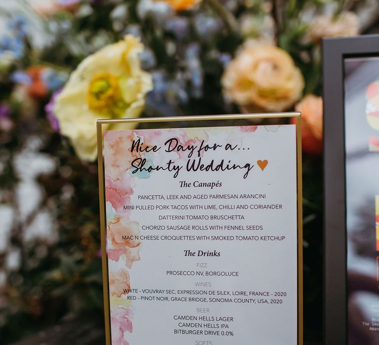 Menu card with multi-coloured watercolour design inn gold frame