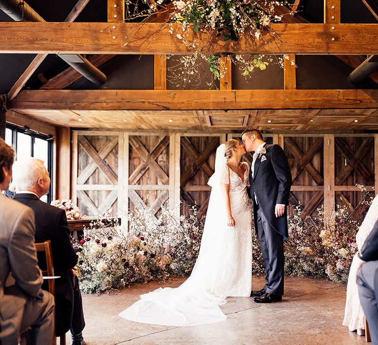 Bride and groom share a kiss during their traditional wedding ceremony