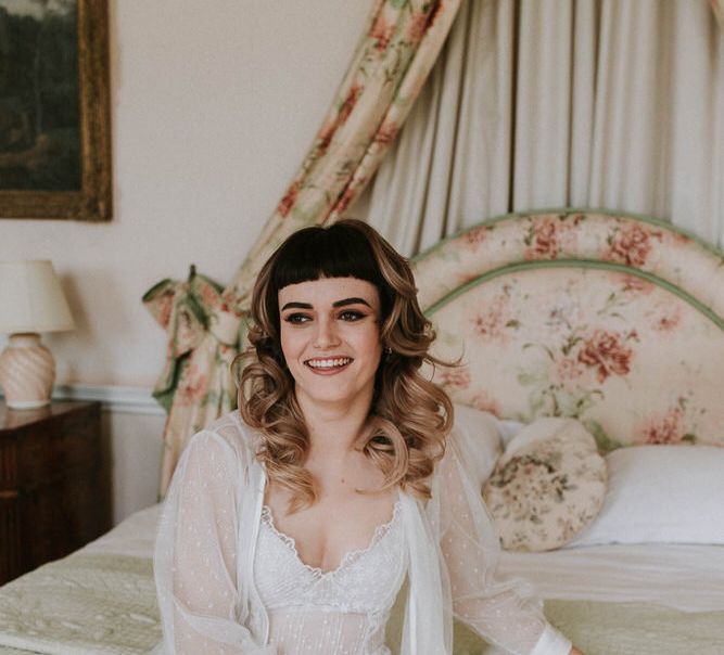 bride-to-be on her wedding morning in wedding lingerie sitting on the bridal bed