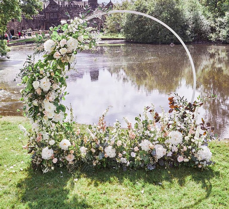 Outdoor wedding ceremony at East Riddlesden Hall with hoop floral arch 