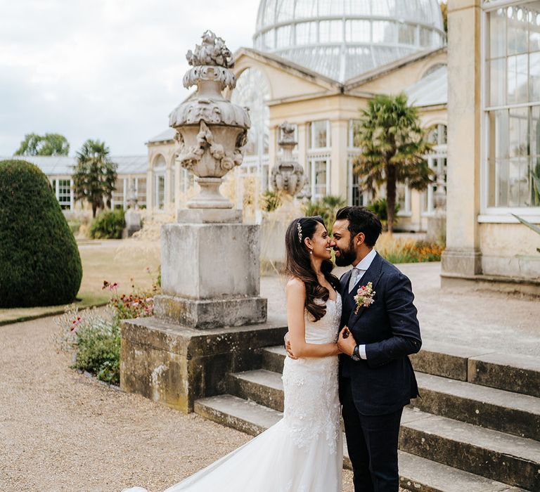 Bride & groom stand outside Syon Park before wedding reception in the Great Conservatory 