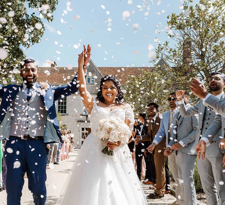 Bride & groom walk through white confetti during Sri Lankan wedding 