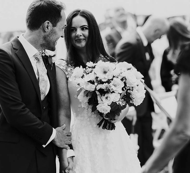 Bride and groom look lovingly at each other for their English country garden wedding 