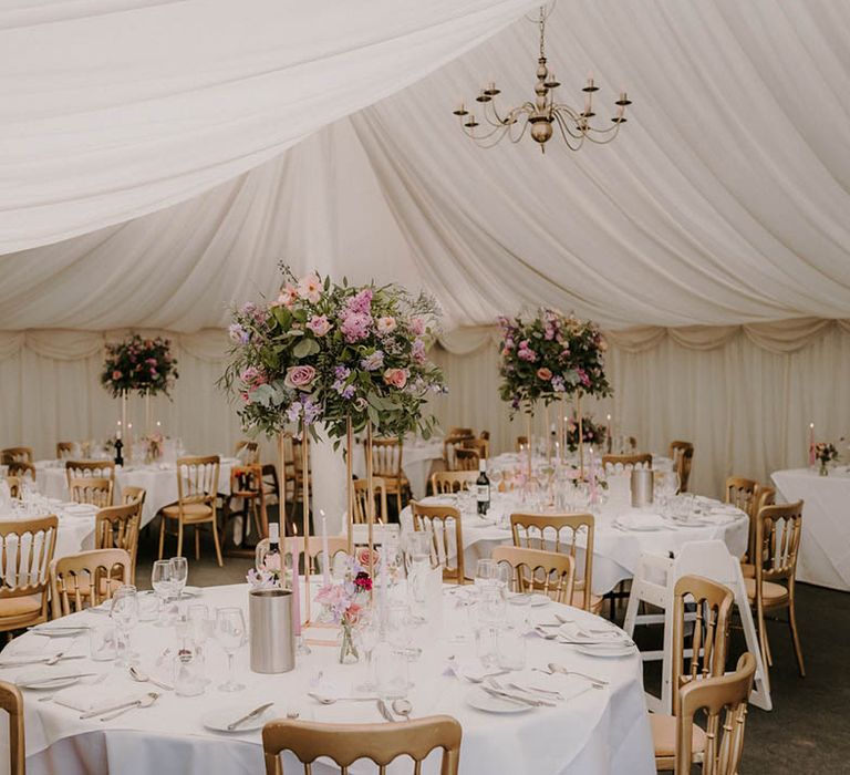 White luxury white wedding marquee reception with a pale lilac tablescape and purple wedding flowers 