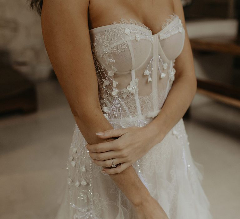 Bride wears corset styled wedding dress with eyelash lace and and delicate floral embellishment 