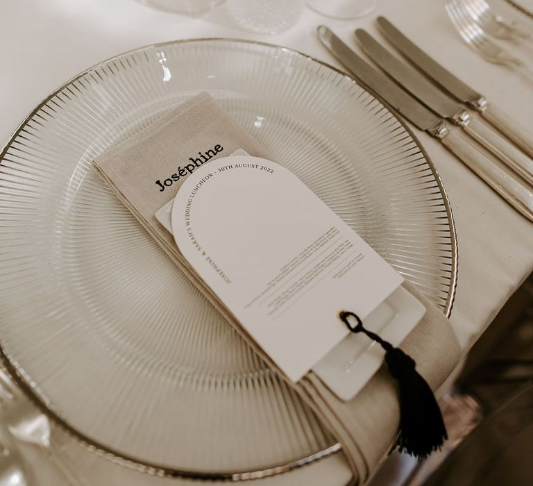 Silver striped and rimmed charger plates with personalised embroidered napkins and black and white wedding menus 