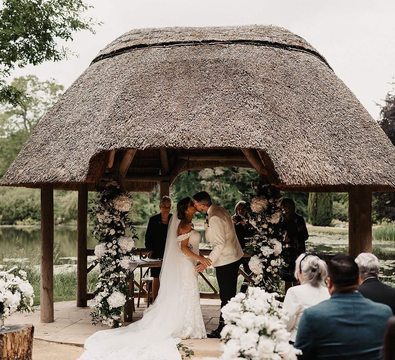 The bride and groom share their first kiss as a married couple at their outdoor ceremony at The Orangery in Kent