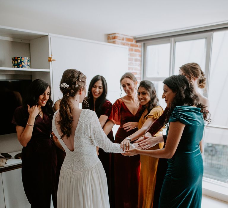 Bride in vintage long sleeved lace wedding dress with open back detail and bridal party in mismatched velvet bridesmaid dresses 