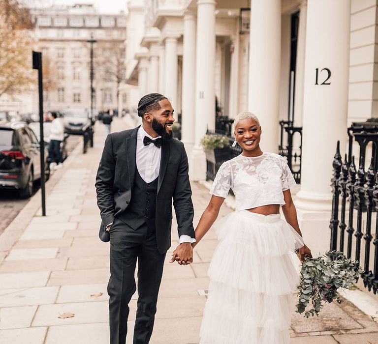 Black Bride and Groom walking through London in black suit and Bridal two piece set