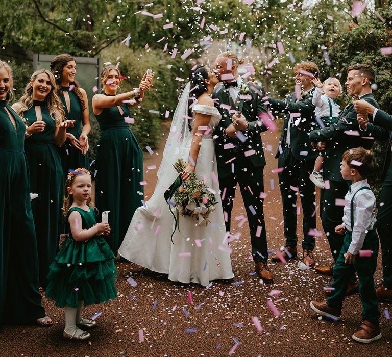 Wedding party releases colourful confetti canons around bride & groom after outdoor wedding ceremony at the Royal Botanic Garden Edinburgh