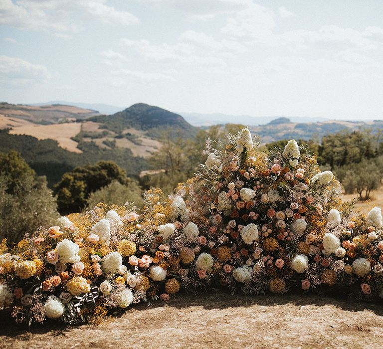 Crown shape wedding altar flowers installation for outdoor wedding ceremony in Tuscany 