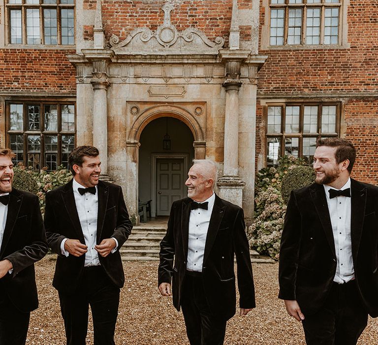 Doddington Hall and Gardens country house wedding venue in Lincolnshire with the groomsmen and groom in traditional black velvet tuxedos 