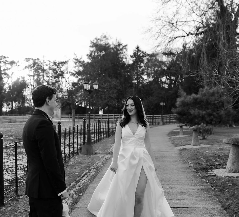 Bride with thigh-high split wedding dress walking through Upton Barn & Walled Garden wedding venue