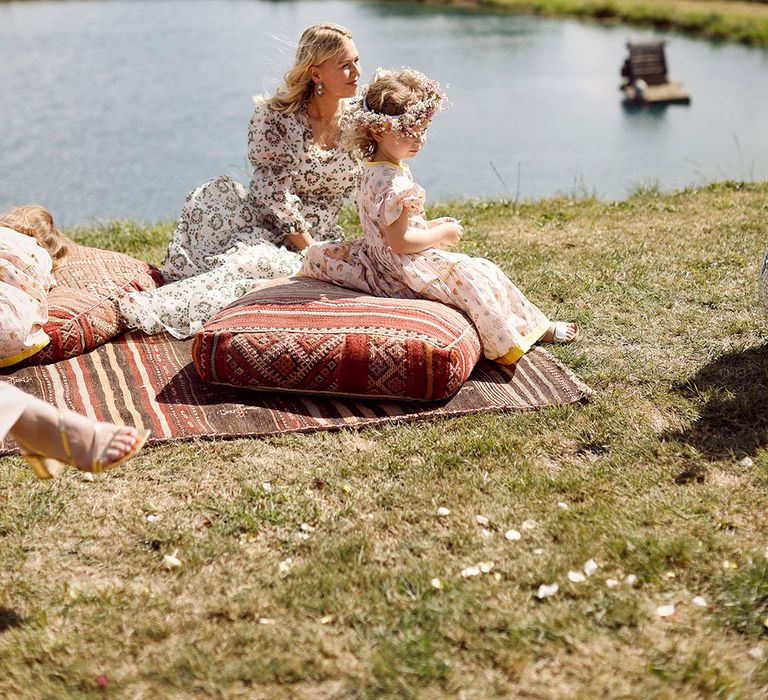 Kids at the wedding with bridesmaid sitting on pillows for relaxed outdoor humanist ceremony 