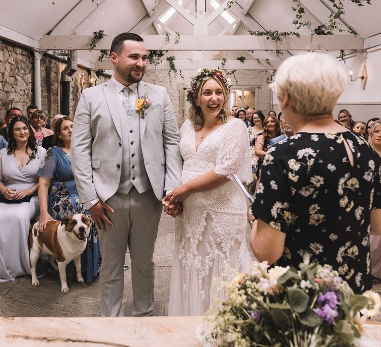 The bride and groom walk back down the aisle with their pet dog, Patch 