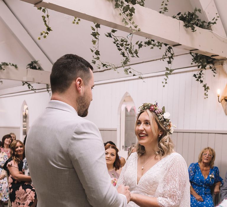 Lancashire wedding with the bride in a lace gown and wildflower wedding crown with groom in light grey suit 