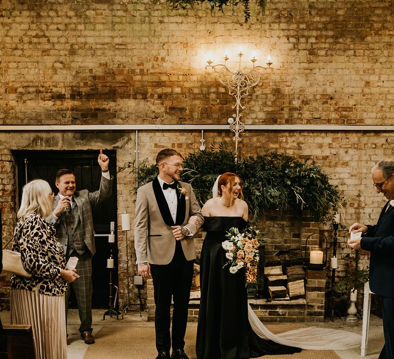 The bride and groom turn to face their wedding guests as they are announced as husband and wife