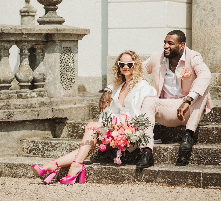 Cornwall country house wedding at Polstrong Manor with bride in short wedding dress with groom in baby pink suit 