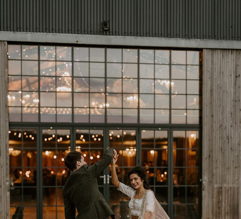 October wedding in Yorkshire with the bride and groom dancing around their rustic barn wedding venue 