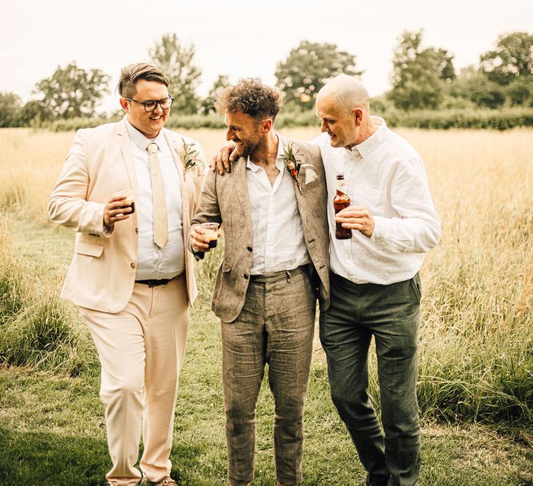 The groom laughs with the wedding guests as they pose for a picture 