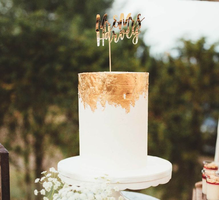 Winter wedding cake single tier with a gold ombre icing style and personalised gold cake topper 