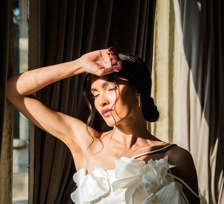 Bride wearing intricate 3D flower wedding dress with her hair in an elegant updo