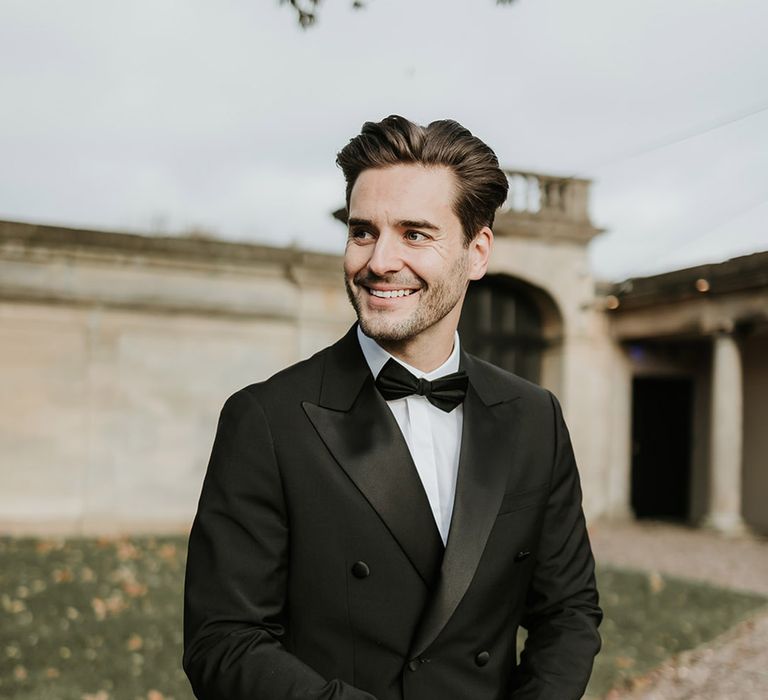 Groom wearing black tuxedo fro elegant and timeless country house wedding 