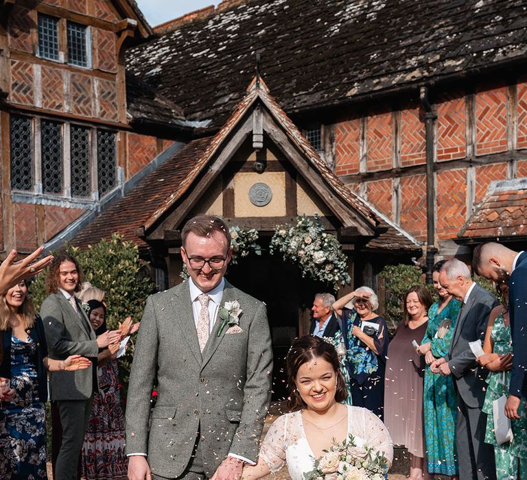 Bride with dwarfism walking with the groom for their traditional wedding confetti exit 