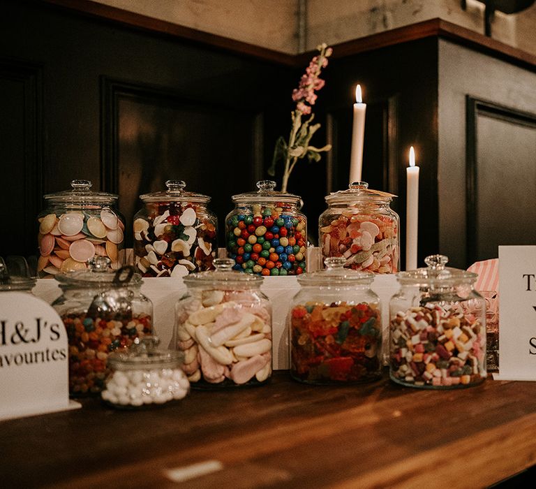 Wedding dessert table with sweet jars for wedding guests 