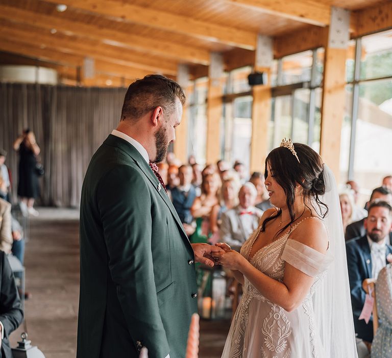 The bride and groom exchange wedding rings as part of their ceremony 