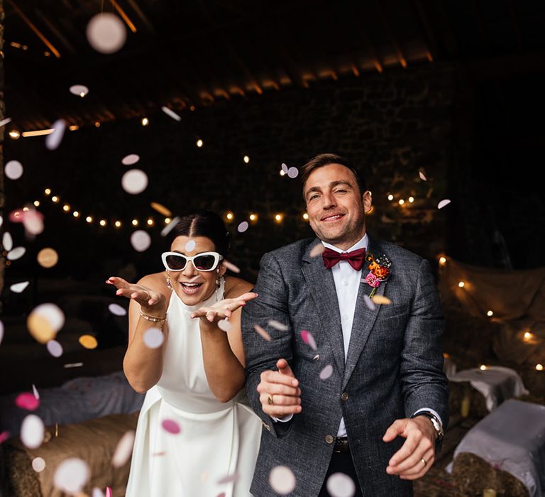 The bride and groom blow confetti in fun wedding photo idea 