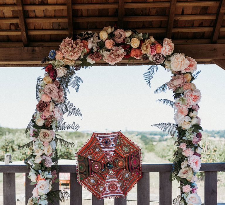 flower arch and colourful parasols 